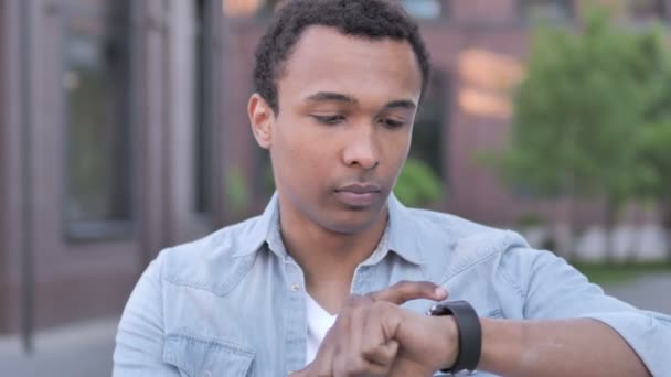 Afrikaner mit Smartwatch im Freien — Stockvideo