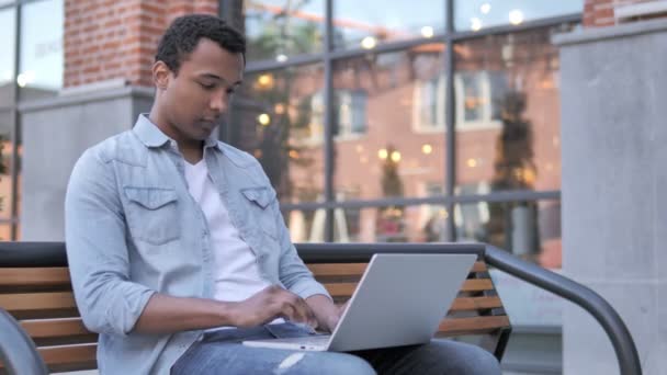 Afrikaner feiert auf Laptop vor Büro — Stockvideo