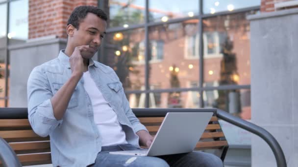 Afrikaner mit Nackenschmerzen benutzt Laptop im Freien — Stockvideo
