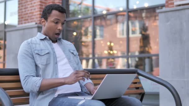 African Man in Shock while working on Laptop Outdoor — стоковое видео