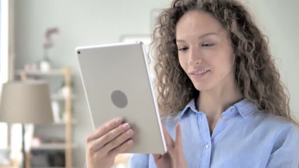 Frau mit lockigem Haar surft auf Tablet — Stockvideo