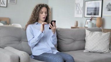 Telefon kullanırken kayıp tarafından şok kıvırcık saç kadın