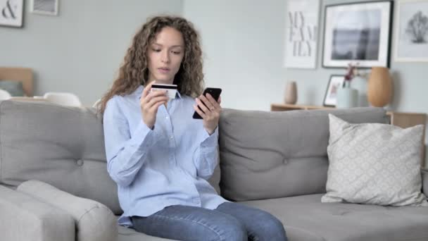 Aufgeregte Frau mit lockigem Haar kauft erfolgreich online auf dem Smartphone ein — Stockvideo