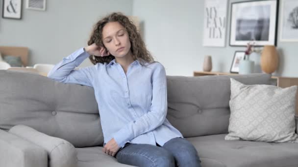 Müde Frau mit lockigem Haar schläft während sie auf der Couch sitzt — Stockvideo