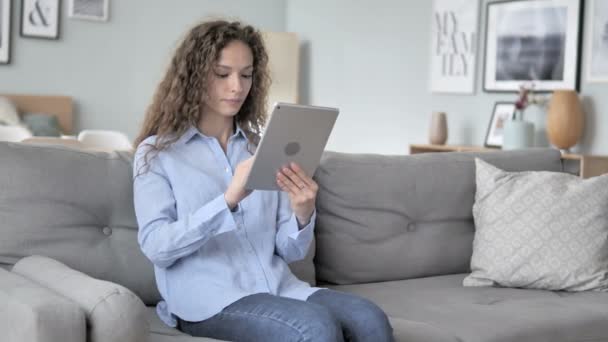 Online winkelen op Tablet door krullend haar vrouw zittend op de Bank — Stockvideo