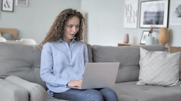 Capelli ricci donna celebrando il successo sul computer portatile — Video Stock