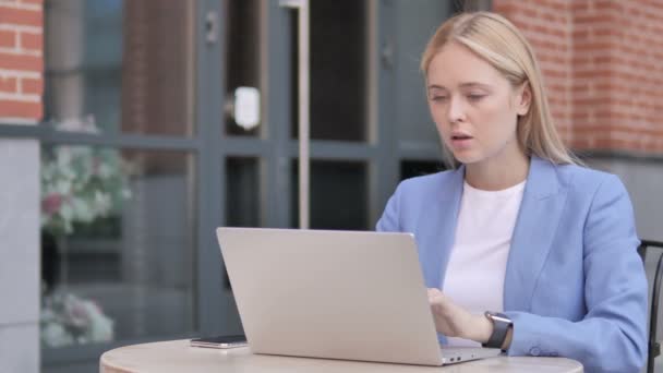 Jonge zakenvrouw met nekpijn met behulp van laptop buiten — Stockvideo