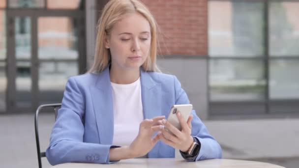 スマートフォンでの成功に興奮する若いビジネスウーマン — ストック動画