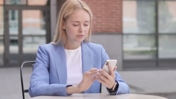 Jonge zakenvrouw boos door verlies tijdens het gebruik van smartphone — Stockvideo