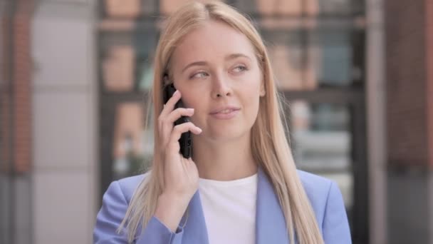 Joven empresaria hablando por teléfono al aire libre — Vídeos de Stock