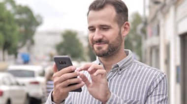 Akıllı telefon kullanarak açık sakal Casual Man