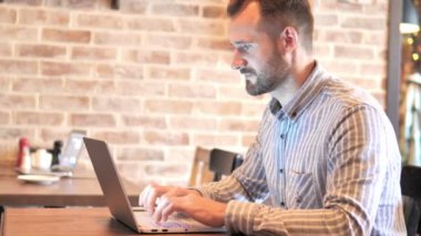 Sakal Casual Man Loft yerde laptop kutluyor