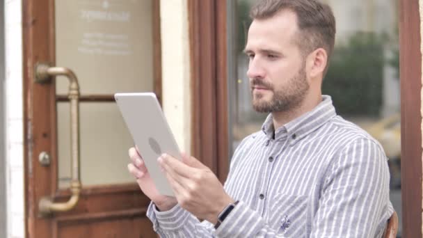 Barba hombre casual usando tableta al aire libre — Vídeos de Stock