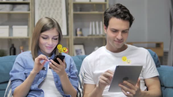 Pareja joven usando Smartphone y Tablet, Volando emoticonos, emojis y gustos — Vídeo de stock