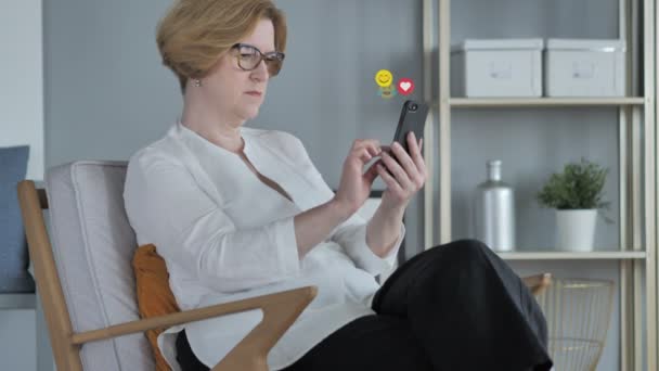 Розслаблююча стара жінка за допомогою смартфона, Emojis, смайлики і любить — стокове відео