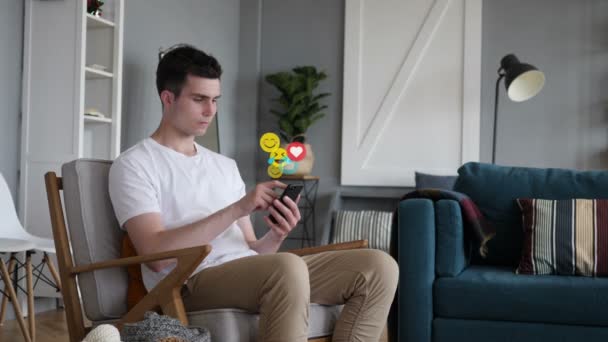 Avslappende ung mann som bruker Smartphone, Emojis, Smileys og Likes – stockvideo