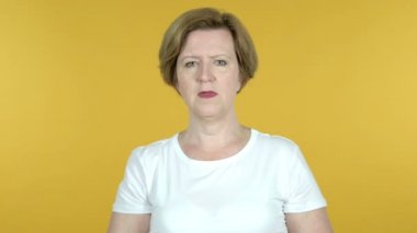 Sarı arka planda Izole baş ağrısı ile yaşlı kadın