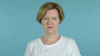Mavi arka planda Izole yaşlı kadın gülümseyen