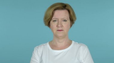 Yaşlı kadın esneme ve mavi arka planda Izole vücut germe