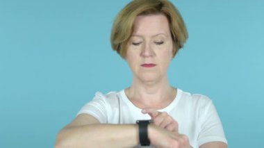 Üst düzey kadın kullanarak SmartWatch mavi arka planda Izole