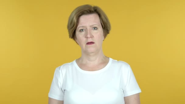 Ledsen upprörd gammal kvinna isolerad på gul bakgrund — Stockvideo