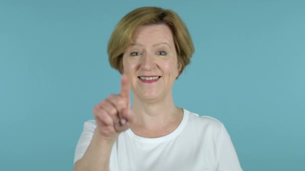 Gammal kvinna bjuder in kunder med båda händerna isolerade på blå bakgrund — Stockvideo