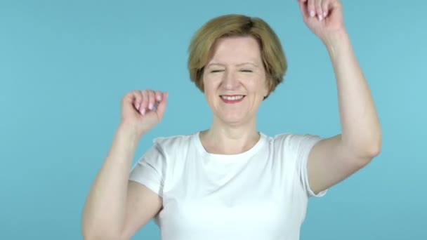 Gelukkige oude vrouw dansen geïsoleerd op blauwe achtergrond — Stockvideo