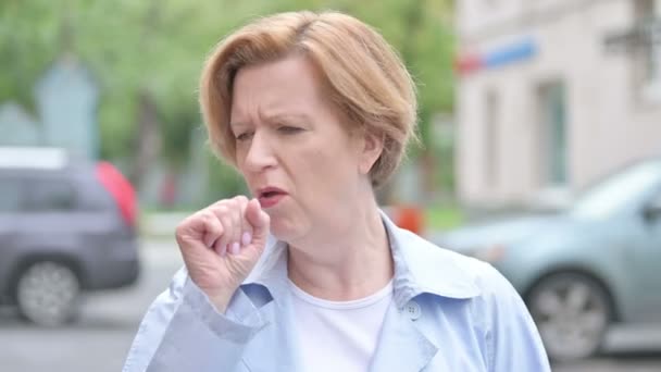 Стоя на улице, больная женщина кашляет — стоковое видео
