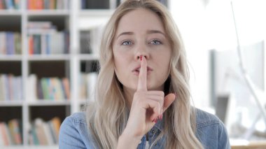 Dudaklar üzerinde Finger, Genç Sarışın kadın Gesturing Silence