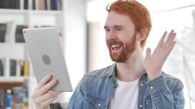 Genç Casual Redhead adam tarafından tablet online görüntülü sohbet