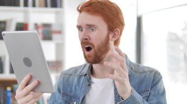 Tablet kullanırken genç Casual Redhead adam kaybına tepki