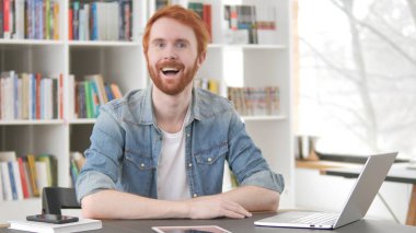 Konuşan heyecanlı genç Redhead adam içinde ofis