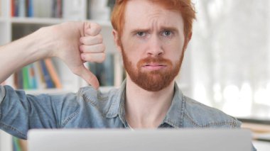 Thumbs aşağı tarafından genç Casual Redhead adam bakıyor içinde kamera at Iş