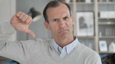 Thumbs Down orta yaşlı adam Iş yerinde, kamera bakıyor