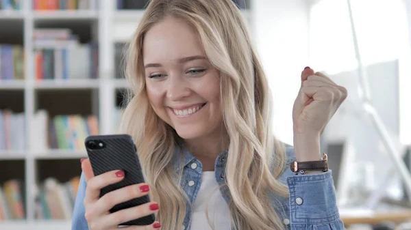 Joven mujer rubia disfrutando del éxito en el teléfono inteligente — Foto de Stock