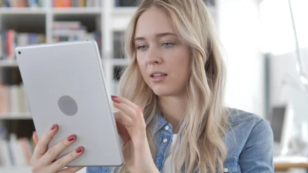 Молодая блондинка просматривает интернет на планшете — стоковое фото