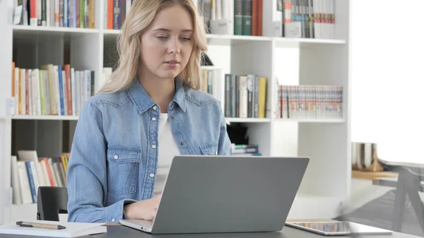 Красивая молодая блондинка работает на ноутбуке — стоковое фото