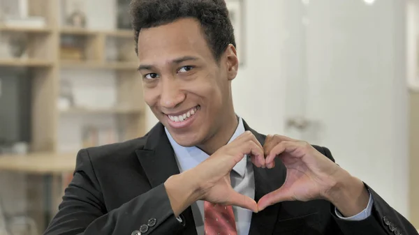 Signo del corazón de un joven empresario africano — Foto de Stock