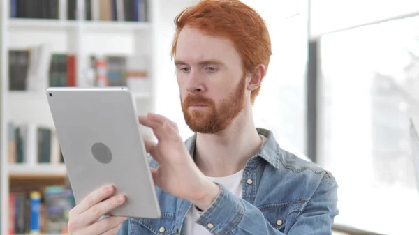 Jonge casual Redhead man browsen op Tablet — Stockfoto