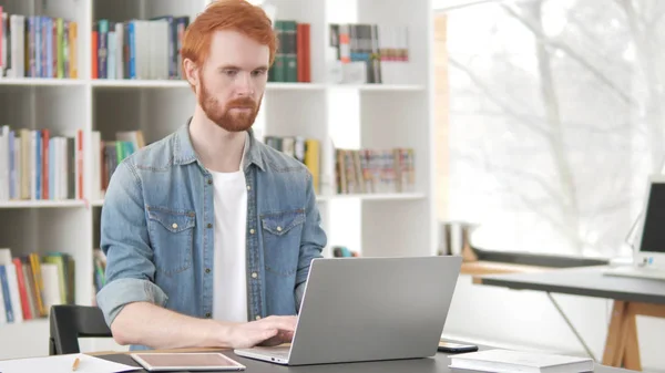 Busy Young Casual Redhead Man Working On Laptop