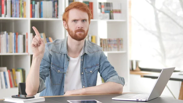 Young Casual Redhead Man Waving Finger to Reject at Work
