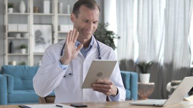 Kıdemli doktor tarafından hasta ile tablet üzerinden görüntülü sohbet
