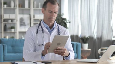 Online bilgi için tablet kullanarak kıdemli doktor