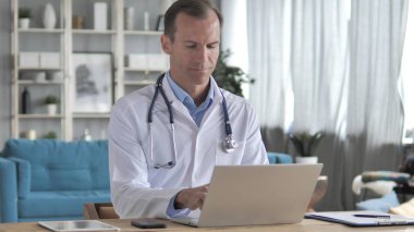 Kıdemli Doktor yazma on laptop klinikte, e-posta gönderme