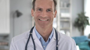 Klinikte başarılı gülümseyen kıdemli doktor