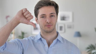 Thumbs Down tarafından yakışıklı genç adam Iş yerinde, bakıyor kamera