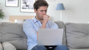 Yaratıcı ofiste laptop çalışırken hasta yakışıklı genç adam öksürük