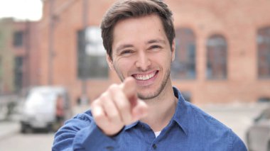 Açık ayakta genç adam kamera doğru parmak ile Işaret