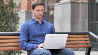 Genç adam laptop üzerinde çalışan, Bench açık oturma