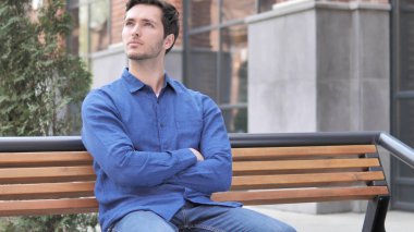 Genç adam oturma açık üzerinde Bench